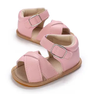 Close-up of pink baby girl walking shoes with soft rubber soles and silver buckles.