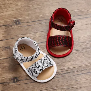 Detail view of breathable knit baby walking shoes with velcro straps on wood surface