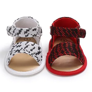 Close-up detail of breathable soft-sole baby walking shoes in black, white, and red