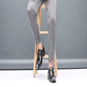 Vue détaillée de chaussures en cuir noir pour homme avec un pantalon à carreaux.