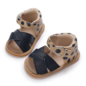 Close-up detail view of navy blue polka dot baby girl sandals with soft rubber sole