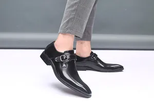Vue détaillée des chaussures en cuir noir à boucle portées avec un pantalon gris