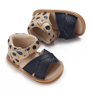 Detail of baby girl walking shoes with beige polka dots and black cross straps.