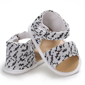 Close-up of infant pre-walker sandals with black and white patterned fabric and soft sole.