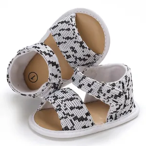 Detail of soft-sole baby walking shoes with black and white houndstooth pattern.