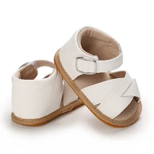 Detailed side view of white baby sandals with soft rubber sole and buckle strap