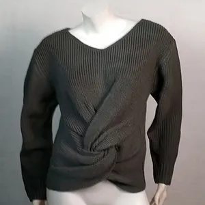 Detalle de jersey de punto verde oliva con cuello en V y un nudo retorcido delantero