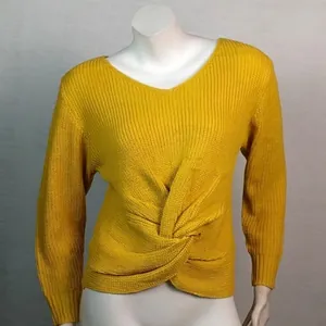 Primer plano de un suéter de punto amarillo con un elegante detalle de nudo en el frente