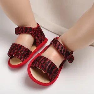 Detailed close-up of breathable red and black patterned baby walking sandals with soft soles