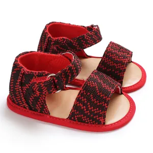 Detailed close-up of red and black checkered baby toddler sandals with soft soles.
