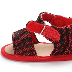 Close-up detail of red and black mesh baby sandal with adjustable hook-and-loop strap