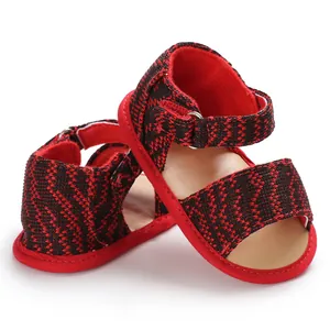 Detail view of red and black woven baby walking sandals featuring comfortable soft soles