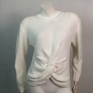 Primer plano de un jersey de punto blanco con cuello en V y detalle de nudo frontal.