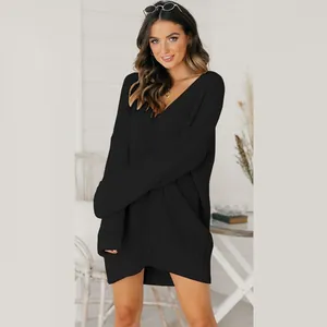 Detailed look at a black loose V-neck knitted sweater dress on a female model.
