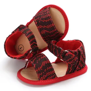 Detailed view of red and black patterned baby walking sandals featuring soft breathable soles.
