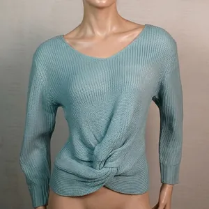 Detalle de suéter de punto azul claro con elegante nudo delantero y cuello en V