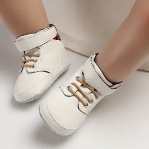 Close-up of white high-top baby walking shoes with soft soles and velcro straps for infants.