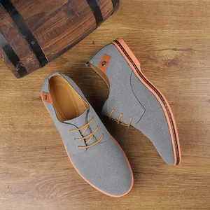 Premium graue Wildleder-Freizeitschuhe für Herren mit orangefarbenen Schnürsenkeln auf Holz