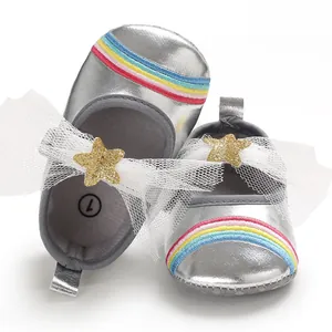 Detailed view of silver baby girl walking shoes with rainbow stripes and tulle bow