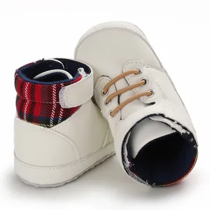 Detailed view of white high-top baby walking shoes with plaid collar and soft sole.