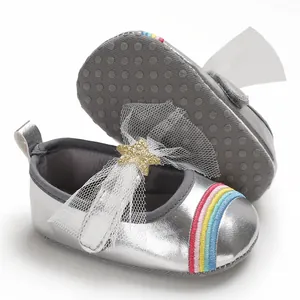 Close-up of metallic silver baby princess shoes featuring rainbow embroidery and white tulle bow