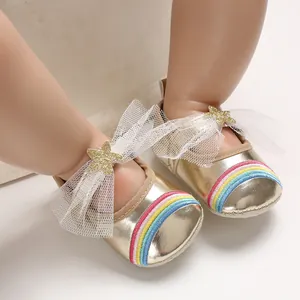 Detailed view of gold baby princess shoes with rainbow embroidery and mesh star bow.