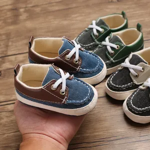 Close-up van blauw-bruine babyschoentjes met zachte zool op een houten ondergrond