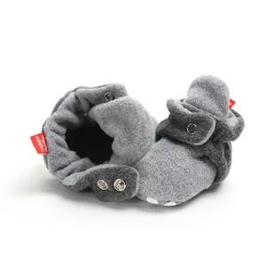 Detailed view of grey fleece baby winter booties with soft soles and snap button closures