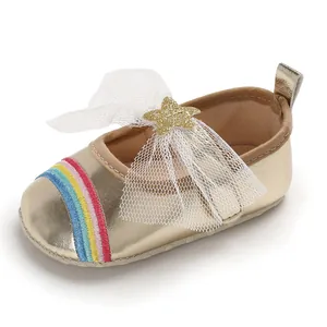 Detailed view of gold infant girl walker shoe with rainbow embroidery and mesh bow