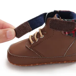 Close-up view of the Velcro strap on brown soft sole high-top baby walker shoes