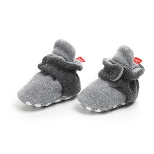 Detailed macro view of grey fleece baby booties with soft non-slip sole for winter warm.