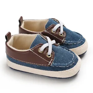Detailweergave van denim babyloopschoenen met zachte zool en bruine lederen bies