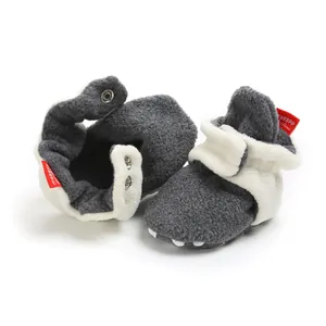 Close-up of warm grey baby winter booties with soft white fleece lining and snap