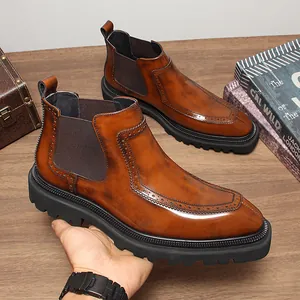 Détail d'une bottine Chelsea en cuir marron avec motifs brogue et semelle épaisse.