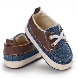 Detailopname van blauwe denim en bruine leren baby wandelschoenen met zachte zolen