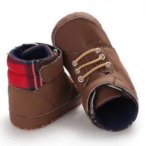 Detail view of brown high-top baby walker shoes with red plaid fabric collar accent