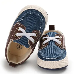 Blauwe denim baby loopschoentjes met bruine accenten en een zachte witte geweven zool.
