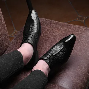 Gros plan de chaussures pour hommes en cuir noir embossé crocodile avec détails wingtip