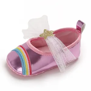 Detailed macro view of pink metallic baby girl walking shoe with rainbow and mesh bow decoration