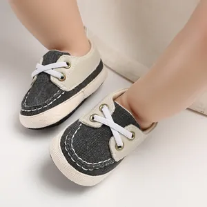 Detail van zachte baby-loopschoenen gemaakt van denimstof met decoratieve witte veters
