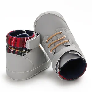 Detail view of grey baby high-top walking shoes with plaid lining and soft soles