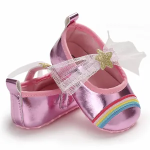 Close-up of pink metallic baby girl walking shoes with a white mesh bow and rainbow detail