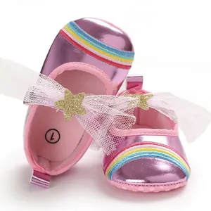 Detail view of pink metallic baby girl walking shoes featuring rainbow and star lace bow