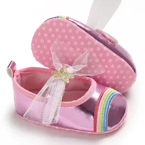 Detail shot of baby girl shoes featuring metallic pink leather and rainbow embroidery design
