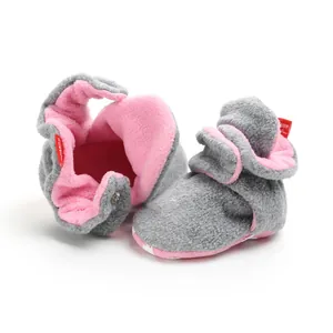 Detail of soft fleece baby winter booties with pink lining and grey exterior