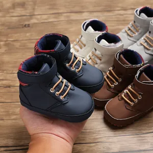 Close-up of colorful high-top baby walker shoes with soft soles on a wooden background.