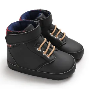 Close-up of black high-top infant walking shoes with soft soles and velcro strap closure