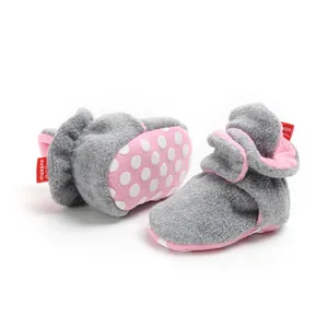 Detailed view of grey and pink baby fleece winter boots with soft polka dot soles