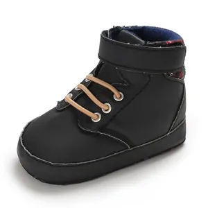 Detail view of black high-top infant toddler shoes with soft soles and plaid collar.