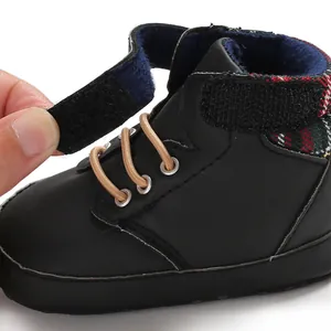 Detail view showing adjustable Velcro closure on black high-top soft sole baby pre-walker shoes